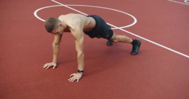 Atletik adamın dışarıda yoğun bir antrenmanı var. Genç kaslı erkek spor alanında çapraz antrenman yapıyor ve egzersiz yapıyor. Genç atletik erkek dışarıda yoğun idman yapıyor.