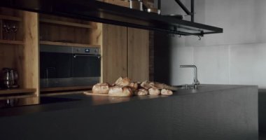 Modern ve geniş ahşap mutfak odası. Gayrimenkul. Ada ve sandalyeli lüks mutfak. Lüks evdeki modern iç mekan ve yemek odası. Yeni Ev 'de minimalist tasarım.