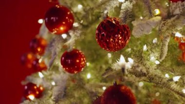 Yeni yıl tatili için hazırlık. Karlı dalları, kırmızı topları ve parlak çelenkleri olan bir Noel ağacı. Yeni yıl süslemeli fidan ağacı. Noel arifesi. Yılbaşı ağacı.