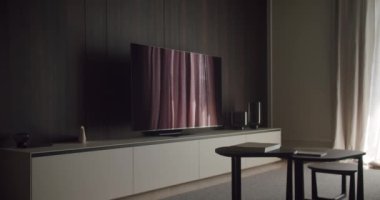 Düz ekran televizyon, gösterişli modern mobilyalar ve bir eğlence biriminde minimalist dekorun yer aldığı şık bir oturma odası. Düz Ekran TV ve Minimalist Dekorlu Modern Oturma Odası