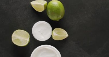 Üst Manzara Beyaz Şişe ve kozmetik için limonlu tüpler stüdyoda siyah bir arka planda dönüyor. Doğal malzemelere dayalı kozmetik yağları, fırça, tonik, vücut bakımı. Kozmetik şişeleri.