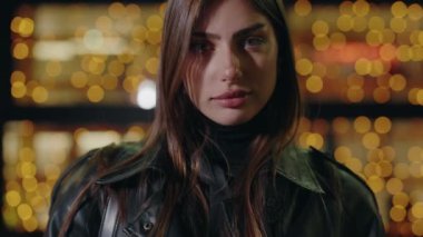 Gece lambalarının arka planında genç bir kadının portresi. Lüks kadın portresi. Çekici bir kadın portresi. Model pozu şehir caddesi. Sokaktaki doğal güzellik kraliçesi. Yavaş çekim.