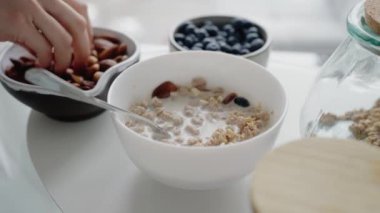 Granola, badem, yaban mersini ve süt içeren besleyici bir kahvaltı görüntüsü. Sağlık ve refah kavramları için mükemmel. Sağlıklı Granola Kahvaltısı, Yabanmersini