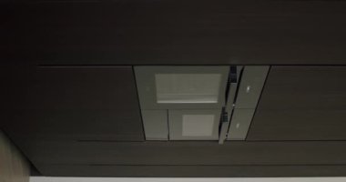 Tavana monte edilmiş modern mutfak egzoz sistemi. Çağdaş iç mekanlar için parlak bir tasarım ve koyu ahşap kaplama. Modern Mutfak Çağdaş Tasarımda Tavana Bağlı Egzoz Sistemi. Dikey