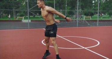 Atletik adam dışarıda antrenman yapıyor ve spor sahasında zıplayarak ve iterek burpee egzersizi yapıyor. Sağlıklı yaşam için çalışıyor. Spor ve spor yaşam tarzı. Spor, sağlık, spor rutini.,