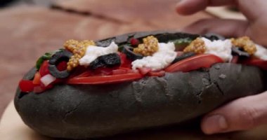 Sosisli sandviç ve hardal ve ketçap, salata ve havuç, domates, zeytin, soğan, salatalık. Ve bir sürü malzeme. Büyük şehirde sokak yemeği. İştah açıcı sosisli sandviç..