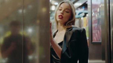 Siyah rujlu, kendine güvenen, parlak ışıklar ve reklamlarla dolu şehir ortamında poz veren kendine güvenen bir kadın. Modaya uygun, modern ve gergin bir ortam. Kentsel Ayarlarda Tarz Kadını