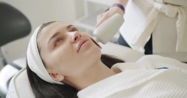 Profesyonel bir kozmetik uzmanı kadın hastalarla güzellik salonunda yüz işlemleri yapar. Yüz derisi mekanik tedavi sürecine yakın çekim. Kozmetik yenilikleri. Modern teknisyen.