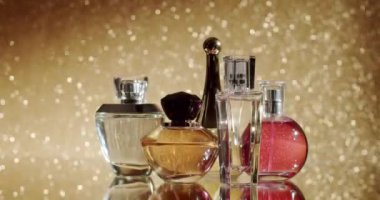 Işıldayan altın bir zemin üzerine kurulmuş çeşitli parfüm şişelerinin sofistike bir gösterisi. Lüks, güzellik ve zarafeti yakalar. Güzel parfüm şişeleri