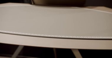 Modern çalışma masasını deri ve beyaz dikişli, rahat bir çalışma odasında ahşap kapatıyoruz. Modern Minimalist çalışma masası. Lüks mobilya ayrıntıları. İş yeri. Modern masadaki güzellik..