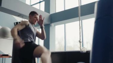 Çağdaş bir spor salonunda antrenman sırasında yüksek tekme atan odaklanmış genç bir erkek atlet. Genç Sporcu Modern Spor Salonunda Yüksek Tekme Uygulaması.