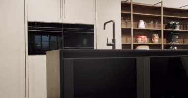 Luxury kitchen with an island. Modern interior in luxury house. Modern Chrome Faucet. Minimalist design in New Home. Real Luxury Design Interior. Neoclassic Style, cozy interior.