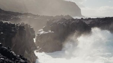 Güçlü okyanus dalgalarının uçurumlara çarptığı Portekiz 'in dramatik kayalık kıyı şeridi sisli bir ortam yaratıyor. Engebeli doğa ve deniz manzarası bu canlı sahnede yer alıyor..
