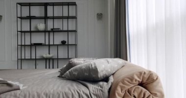 Zarif beyaz ve kahverengi iç tasarım. Minimalist beyaz yatak odası. Minimalist İskandinav tarzı iç mekan. Kral yatağı olan zarif ve basit bir yatak odası. İçi beyaz duvarlarda raflarla dolu..