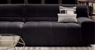 Modern koyu gri kumaş kanepe. Yastıklı tekstil döşeme kanepesi. Modern apartman güzel koyu gri kumaş kanepe minimalist oturma odasında masalı. Gri modern kanepe minimalist odada.