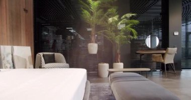 Elegant and Simple Bedroom With a King Sized Bed. Minimalist bedroom. Modern bedroom interior with furniture with double bed and pillows. Luxury home with modern brown wallpaper on the wall.