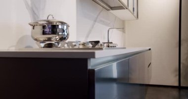 Yemek odasında zarif ve rahat bir ev var. Modern lavabosu olan yerli mutfak. Minimalist yemek masası olan modern mutfak odası. Modern Minimalist Evi. Modern gri ve beyaz mutfak mobilyaları.