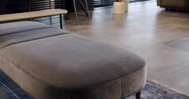Kral yatağı ve rahat koltuğu olan zarif ve sade bir yatak odası. Çift yataklı mobilyalı modern yatak odası. Modern kahverengi duvar kağıtları ve siyah panjurları olan lüks bir ev.