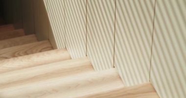 Yakından bakınca krem rengi jaluziler pürüzsüz doğal ahşap zemine gölge düşürüyor. Doğal Ahşap Döşeme Üzerine Krem Renkli Panjurların Yakın Çekimi