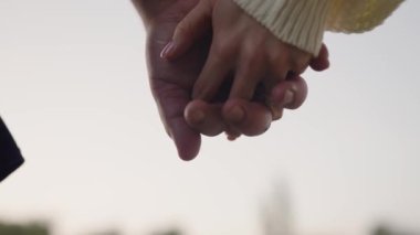 Romantik genç bir çiftin gün batımında el ele tutuşup aşkın ve arkadaşlığın özünü yakalamaları. Romantik Çift Gün Batımında Elele tutuşuyor, Aşkın Sembolü