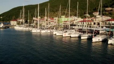 Beyaz yat. Yelkenli. Lüks gemi gezisi. Derin mavi sulardaki beyaz teknenin görüntüsü. Yat gezintisi yapan zengin yatın yukarıdan görünüşü. Lüks gemiyle yaz yolculuğu.