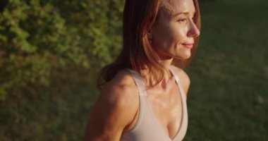 Atletik kadın dışarıda halterlerle egzersiz yapıyor. Güçlü Fitness Vücut Egzersizi. Spor giyim bölümünde halterlerle egzersiz yapan güzel bir genç kadın. Atletik kadın halterleri kaldırıyor..