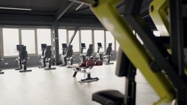 Koşu bantları ve bisiklet makineleri de dahil olmak üzere geniş bir doğal ışık desenine sahip bir dizi kardiyo makinesinin yer aldığı çağdaş bir spor salonu..