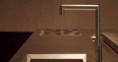 Paslanmaz çelik bir lavabo ve minimalist tezgahın üstünde modern bir mutfak musluğunun yakın çekim görüntüsü. Modern Mutfak Musluğu Paslanmaz Çelik Lavabo ve Tezgahın Üzerinde