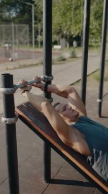 Spor salonunda egzersiz yapan kaslı bir adam güneşli bir parkta güç ve sağlık gösterisi yapıyor. Fiziksel dayanıklılık ve aktif yaşam tarzına odaklan. Dışarıda Egzersiz Yapan Adam