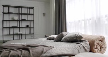 İç dekorasyonun minimalist tarzı. Kral yatağı olan zarif ve basit bir yatak odası. İçi beyaz duvarlarda raflarla dolu. Mobilyalı lüks yatak odası. Zarif beyaz ve kahverengi iç tasarım.