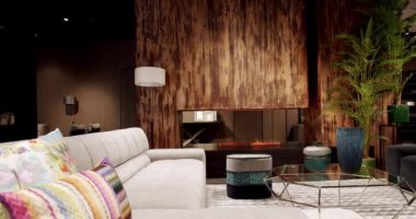 Modern apartman güzel bej kanepe modern oturma odasında lamba, halı, masa. İskandinav iç mimarisi, ahşap duvar, modern gri ve bej kumaş kanepe. Yastıklı tekstil döşeme kanepesi..