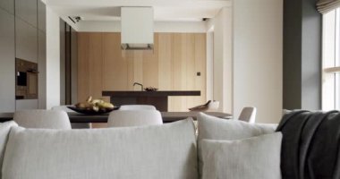 Bir adası olan lüks bir mutfak. Lüks evde modern iç mekan. Minimalist bir mutfağın içinde. Açık Ahşap Duvar ve Zemin. Minimalist yemek masası olan modern mutfak odası..
