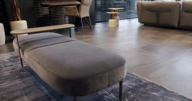 Kral yatağı ve rahat koltuğu olan zarif ve sade bir yatak odası. Çift yataklı mobilyalı modern yatak odası. Modern kahverengi duvar kağıtları ve siyah panjurları olan lüks bir ev.