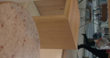 Modern şehir kafesinin dış görünüşü soyut bir perspektifte, ahşap tasarımı ve şehir zeminini vurguluyor. Minimalist mimari ve şehir yaşam tarzını sergilemek için mükemmel. Dikey video.