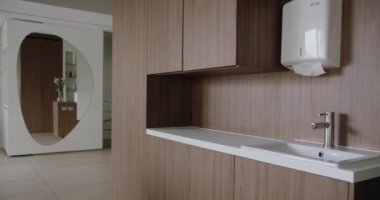 Çağdaş banyo vitrininde minimalist ahşap bir tasarım, parlak bir lavabo, dekoratif bir ayna ve basit bir raf var. Minimum Ahşap Tasarım ve Aynalı Modern Banyo İçi