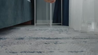 Kapalı alandaki yumuşak halıda çıplak ayakların yakın çekimi. Güneş ışığı perdelerin arasından akıyor. Sıcak bir atmosfer yaratıyor. Yumuşak Ayaklar Kapalı Salonda Güneş Işığı Perdelerin Arasında