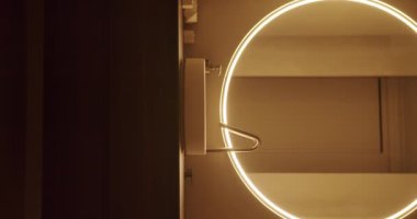 Aydınlatılmış dairesel aynalı, minimalist tasarım estetiğini vurgulayan modern bir banyo. Çağdaş ev dekorasyonu için mükemmel. Modern Banyo Dikey