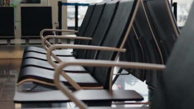 Modern tasarım ve konforun sergilendiği bir havaalanı terminalindeki boş oturma alanı. Seyahat ve ulaşım kavramları için ideal, bekleme, beklenti ve seyahat alanları vurgulanıyor.