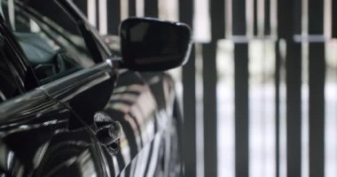 İçeriye park edilmiş lüks bir arabanın yakın çekim görüntüsü. Pürüzsüz tasarımı ve yansıtıcı yüzeyleri ön plana çıkarıyor. Modern Garaja park edilmiş lüks araba, lüks araç tasarımı.