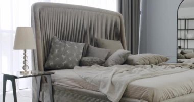 Modern Hotel Yatak Odası İçi ve Yastıklı Yatak. Minimalist İskandinav tarzı iç mekan. Kral yatağı olan zarif ve basit bir yatak odası. Gayrimenkul. Minimalist Kahverengi ve Gri Yatak odası.