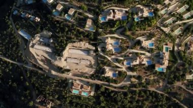 Aerial Upward Shot Of Luxurious Villas with large pool Amidst Green Trees On Mountains. Modern house in a mountain forest. Home exterior with forest. Luxury house in forest.
