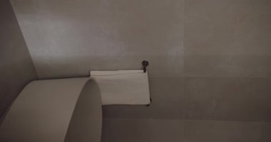 Çağdaş minimalist banyo, gösterişli bir küvet ve duvarda güzelce asılı bir havlu. Tarafsız tonlar ve temiz hatlar modern, sakin bir ortam yaratır. Minimalist Dikey Banyo Tasarımı