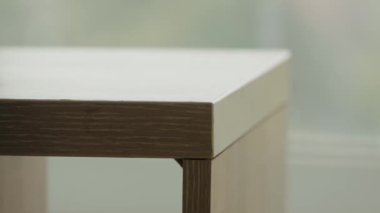 Pencerenin yanındaki boş beyaz masa. Modern basit tasarım tahta masa köşesi yakın plan. Modaya uygun minimalizm, kopyalama alanı. Ürün yerleştirme için mükemmel.