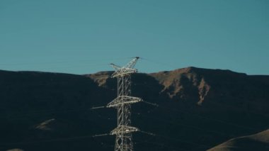 Fas 'ın Atlas Dağları' nda elektrik direği. Bu çarpıcı manzara manzaralı ve engebeli arazi sunarken, elektrik altyapısı doğaya ilginç bir zıtlık ekliyor..