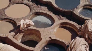 Geleneksel deri bronzlaştırma işleminde kullanılan renkli boyalarla dolu taş fıçılar. Fas 'ın Fez kentindeki Chouara Tannery, canlı bir zanaat merkezidir. Geleneksel Deri Bronzlaşma