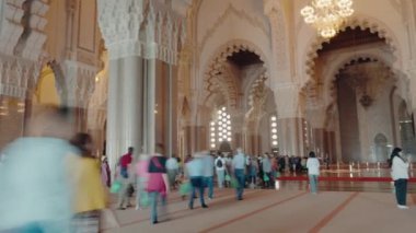 Kazablanka, Fas 'taki Hasan II Camii' nden geçen turistler görülüyor. Zaman aşımı, bu mimari harikanın ihtişamlı ve karmaşık detaylarını yakalar. İslami sanat ve tasarımı gözler önüne serer..