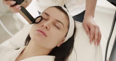 Koruyucu gözlüklü, estetik ilaçlı bir kadın prosedür uyguluyor. Kadın LPG donanım masajı yaptırıyor. Lazer teknolojisiyle mesoterapi gençleştirme. Güzellik tedavisi.