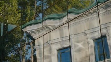 Eski, klasik bir binanın modern bir binanın cam cephesindeki yansıması. Eski ve yeni mimari arasındaki zıtlık büyüleyici. Yansıma görüntüyü bozar,