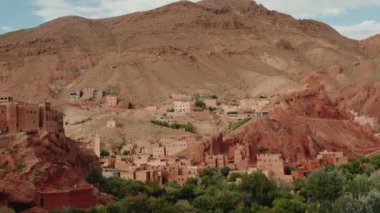 Fas 'taki Dades Vadisi' ne yerleşmiş bir Berber köyünün manzarası. Geleneksel çamur tuğlalı evler yüksek kızıl kaya oluşumlarına karşı kümelenerek büyüleyici bir mimari karışımı oluştururlar..