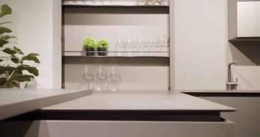 Modern Minimalist Evi. Modern gri ve beyaz mutfak mobilyaları. Yemek odasında zarif ve rahat bir ev var. Modern lavabosu olan yerli mutfak. Minimalist yemek masası olan modern mutfak odası..